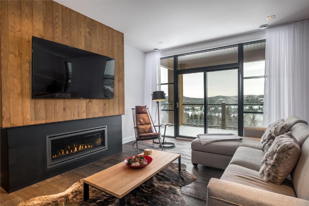 sala de estar con chimenea y TV en Horizon 104 by Tremblant Prestige, en Mont-Tremblant