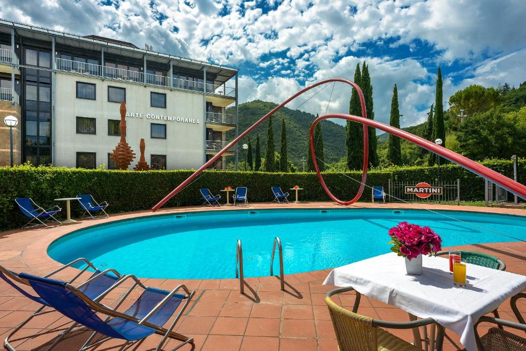 a swimming pool with a slide in front of a hotel at Albornoz Palace Hotel in Spoleto