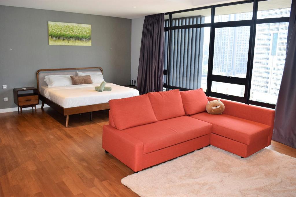 a living room with a couch and a bed at Anggun Residences Luxe in Kuala Lumpur