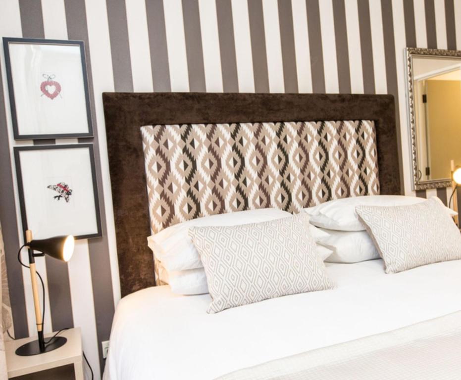 a bedroom with a bed with striped walls at ASURE Destiny on Fitzherbert Motel in Palmerston North