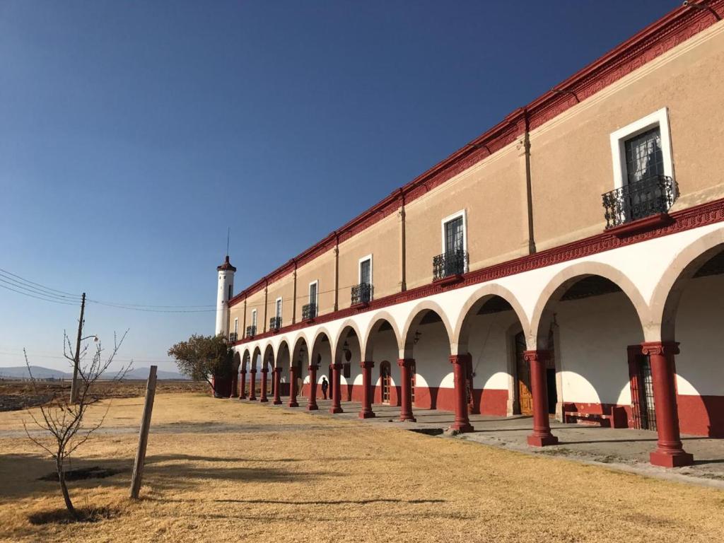 un bâtiment avec des arches et un phare en arrière-plan dans l'établissement Ex-Hacienda San Buenaventura, à San Lorenzo Soltepec