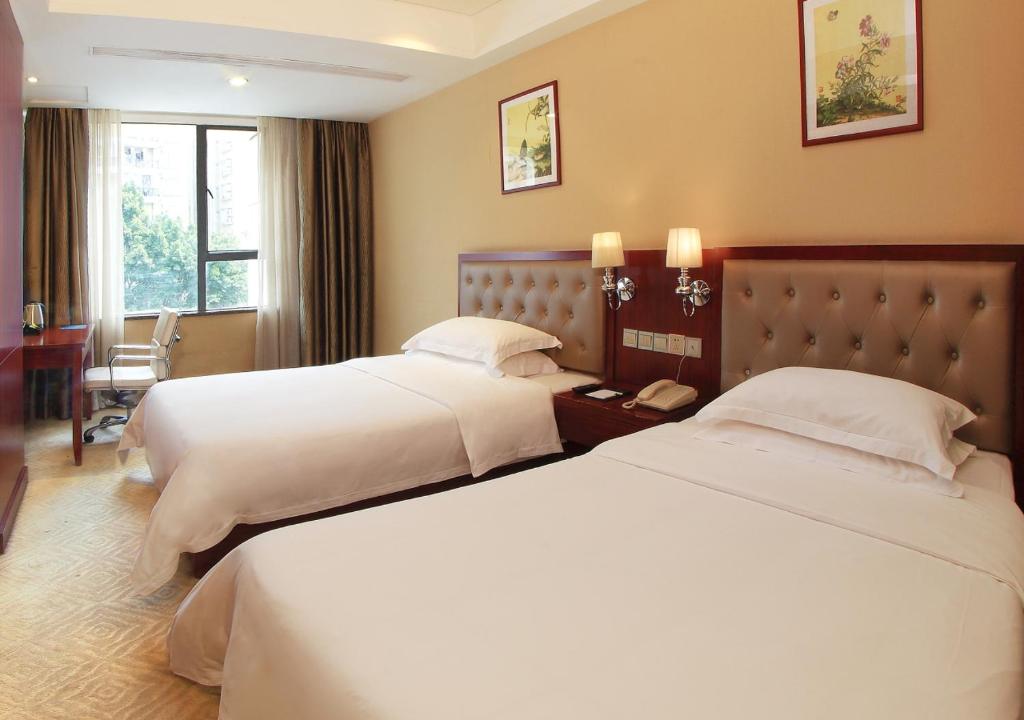 Postel nebo postele na pokoji v ubytování Guangzhou Shi Liu Hotel