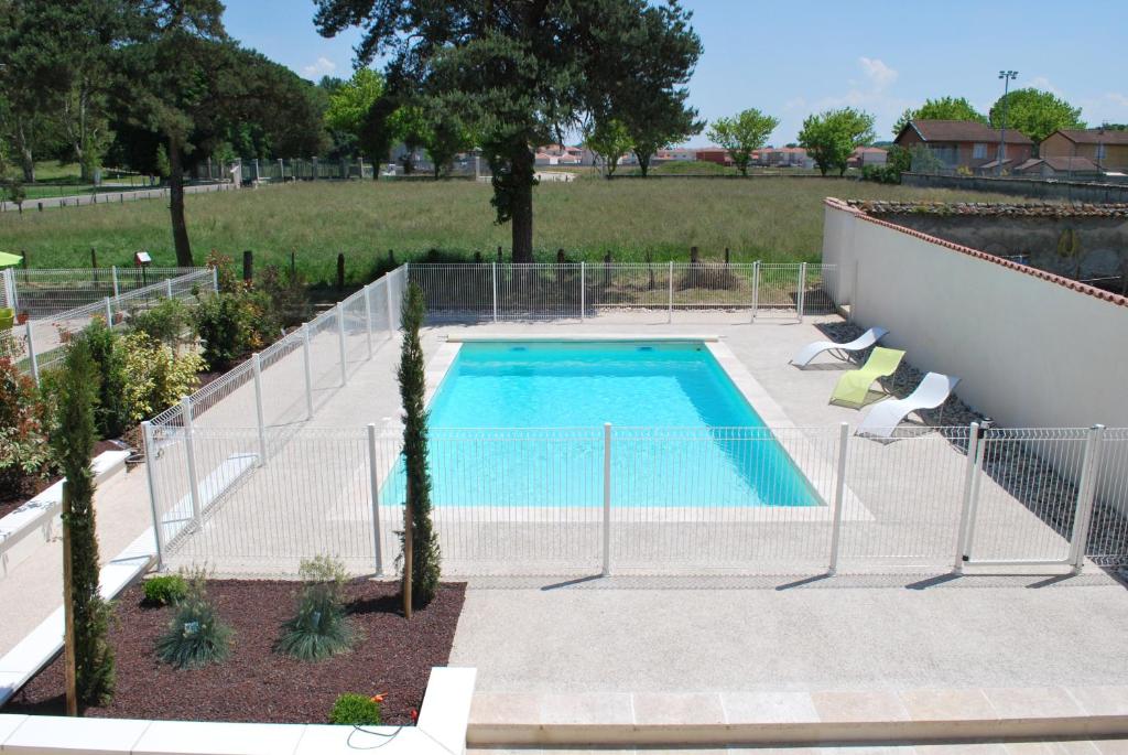 basen z ogrodzeniem wokół niego w obiekcie Chambres d'hôtes La Leva w mieście Villette-dʼAnthon