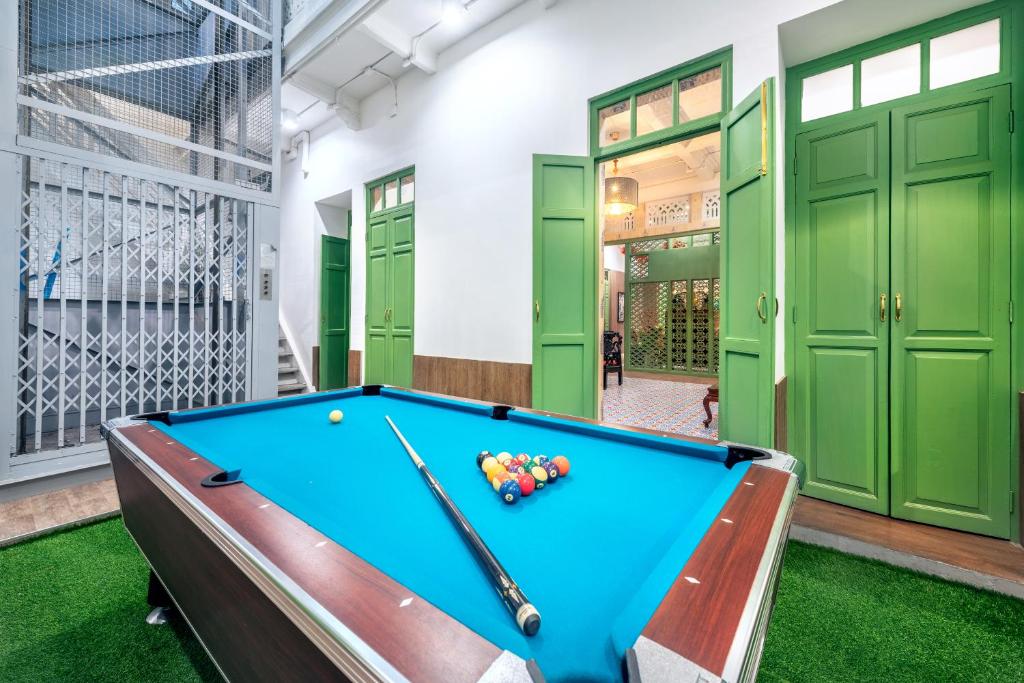 a pool table in a room with green doors at Ama Hostel Bangkok in Bangkok