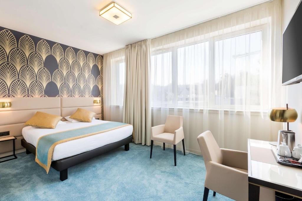 une chambre d'hôtel avec un lit et une chaise dans l'établissement Best Western Hôtel Journel Paris Sud, à Ris-Orangis