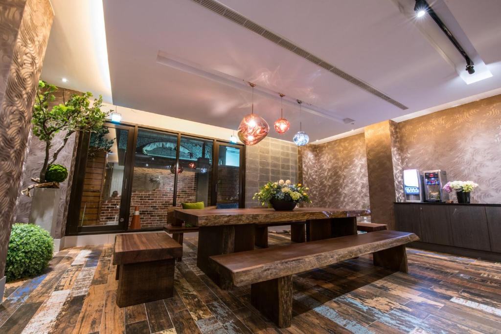 a dining room with a table and benches at Lucky Apple Hotel in Taipei