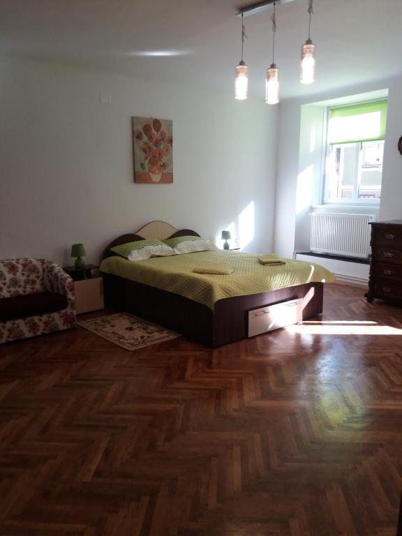 - une chambre avec un lit et du parquet dans l'établissement Charming downtown studio, à Braşov