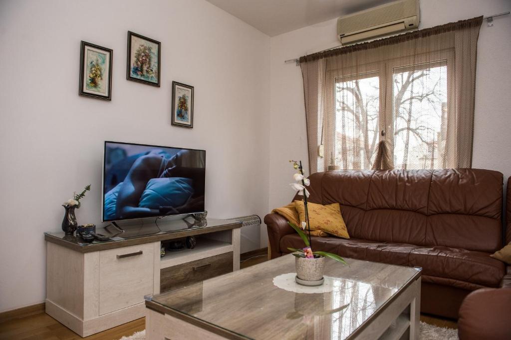 uma sala de estar com um sofá e uma televisão de ecrã plano em Central Place em Trebinje