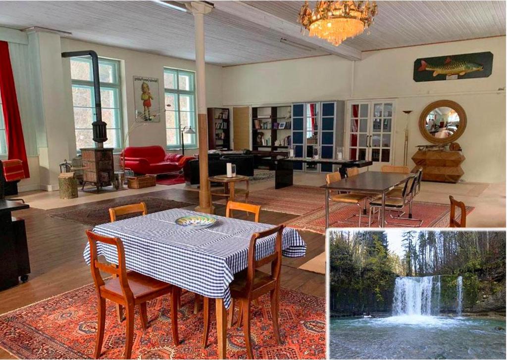 - un salon avec une table, des chaises et une cascade dans l'établissement Loft Chupferhammer & Loft Factory, à Ober-Bazenheid