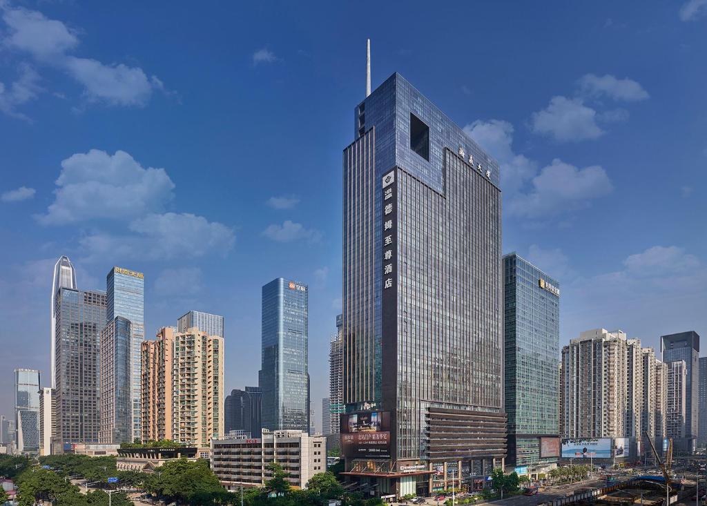 een hoog gebouw midden in een stad bij Shenzhen Futian Wyndham Grand in Shenzhen