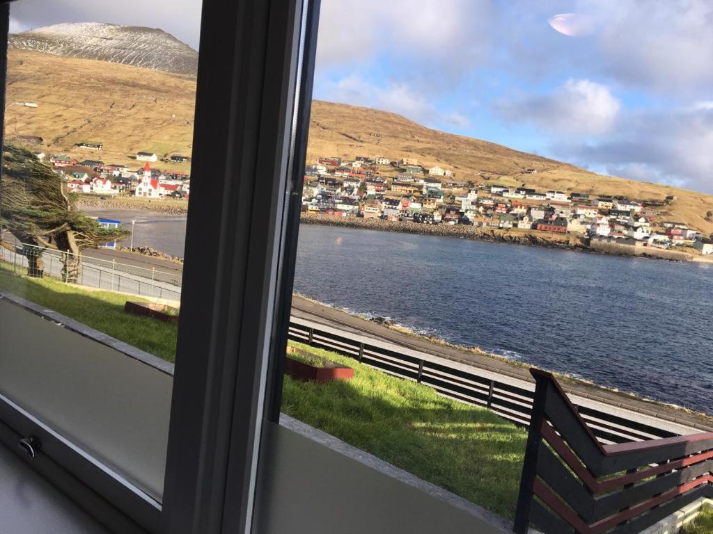 The Atlantic view guest house, Sandavagur, Faroe Islands في Sandavágur: نافذة مطلة على جسم ماء