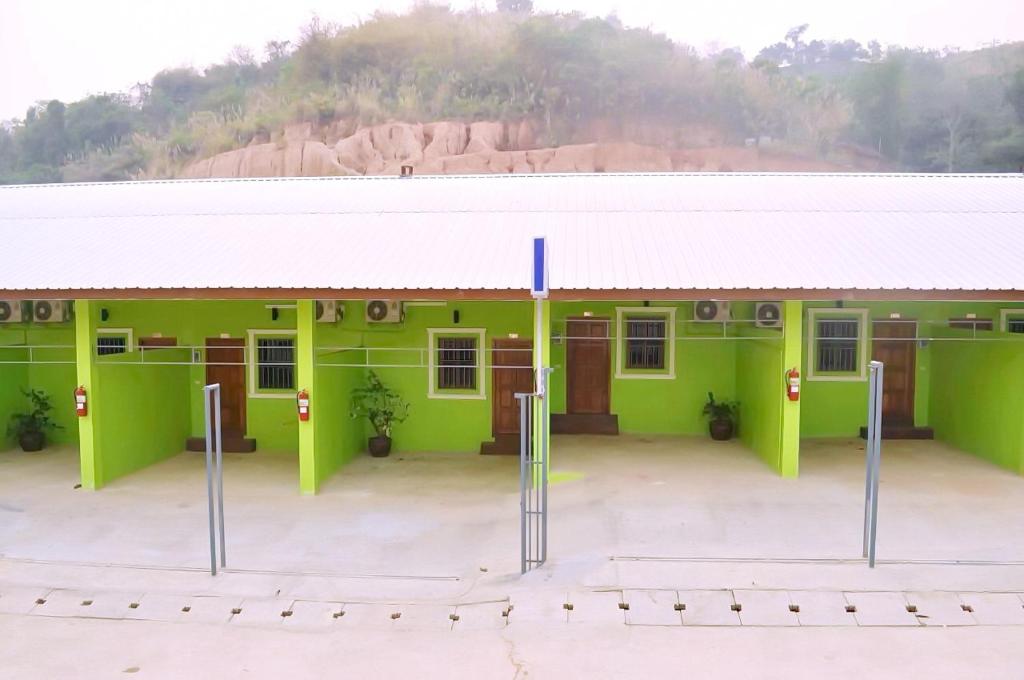 a green building with a white roof at IRIS MOTEL in Tachilek