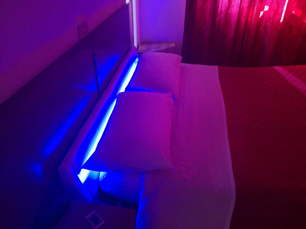 una camera da letto con un letto con luci viola e blu di Hotel Houston Livorno - Struttura Esclusivamente Turistica - Not for Business or Workers a Livorno