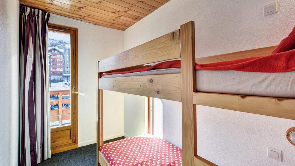 two bunk beds in a small room with a window at Vacancéole - Résidence Vega in Risoul