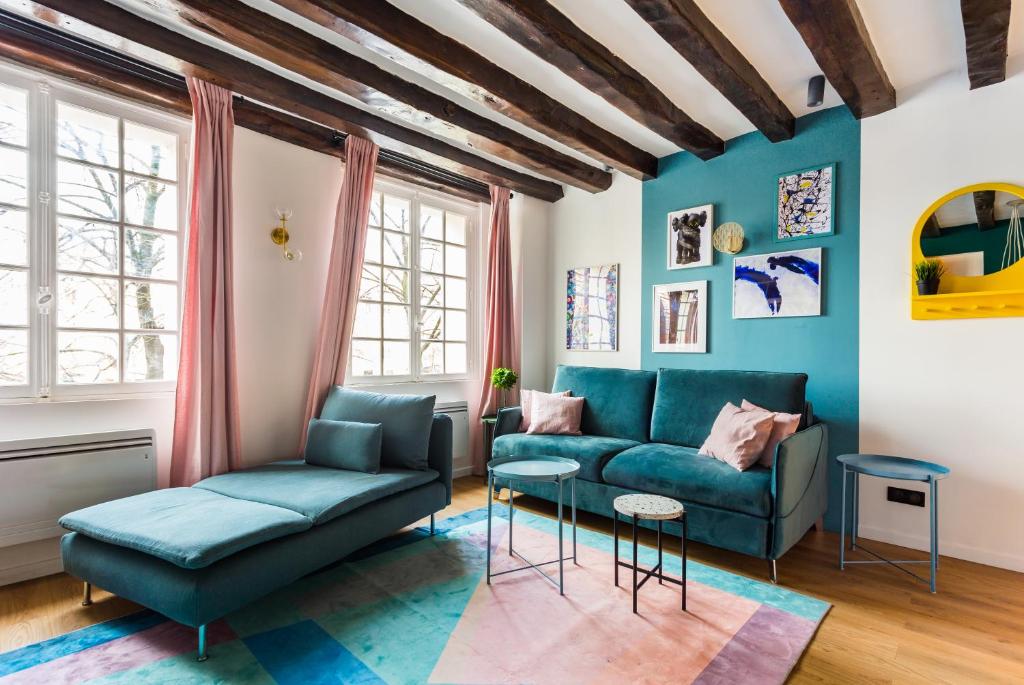 ein Wohnzimmer mit blauen Möbeln und blauen Wänden in der Unterkunft CMG Beaubourg/ Rivoli in Paris