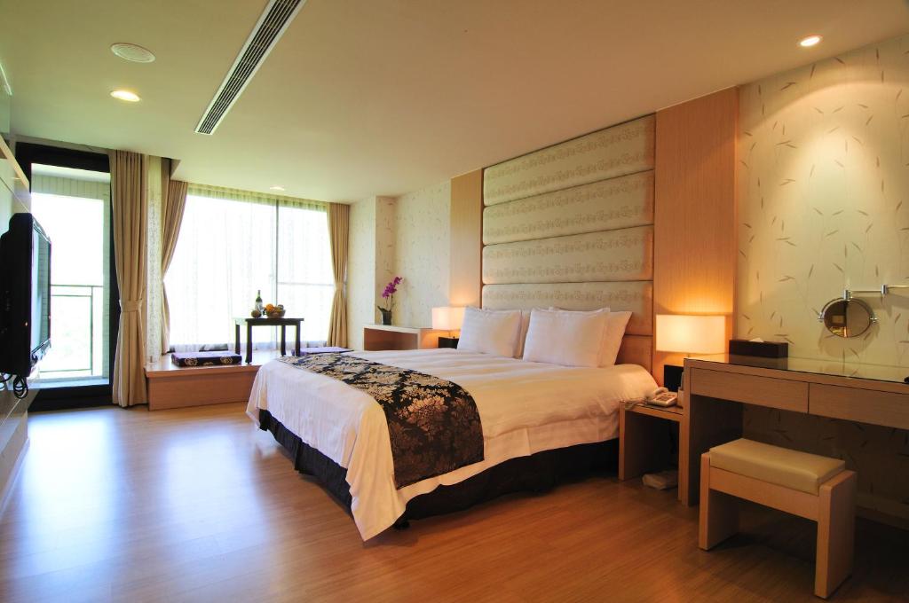 a hotel room with a large bed and a window at Tai-Yi Red Maple Resort in Puli