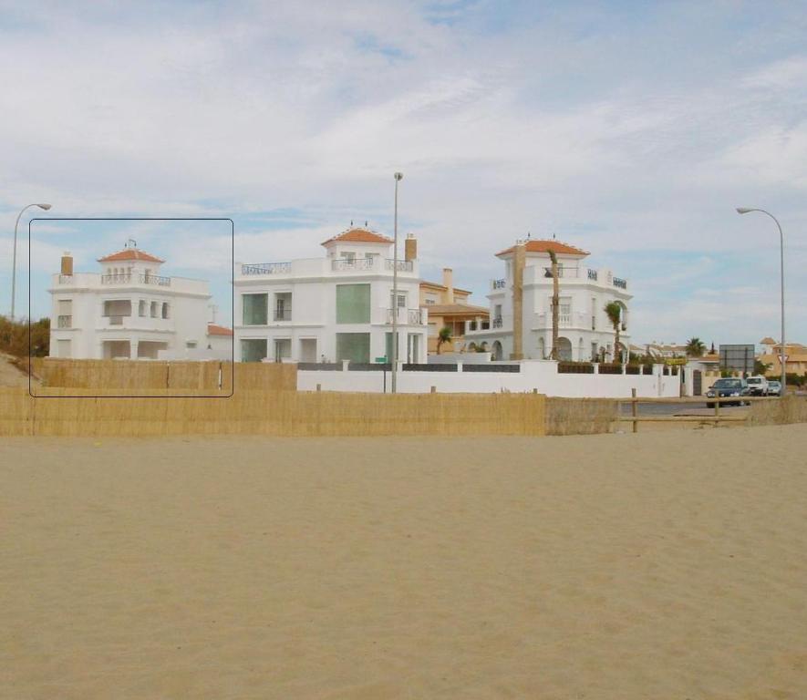 ein Volleyballplatz vor einigen Gebäuden in der Unterkunft Villa Canela with Heated Pool, Piscina Climatizada in Isla Canela