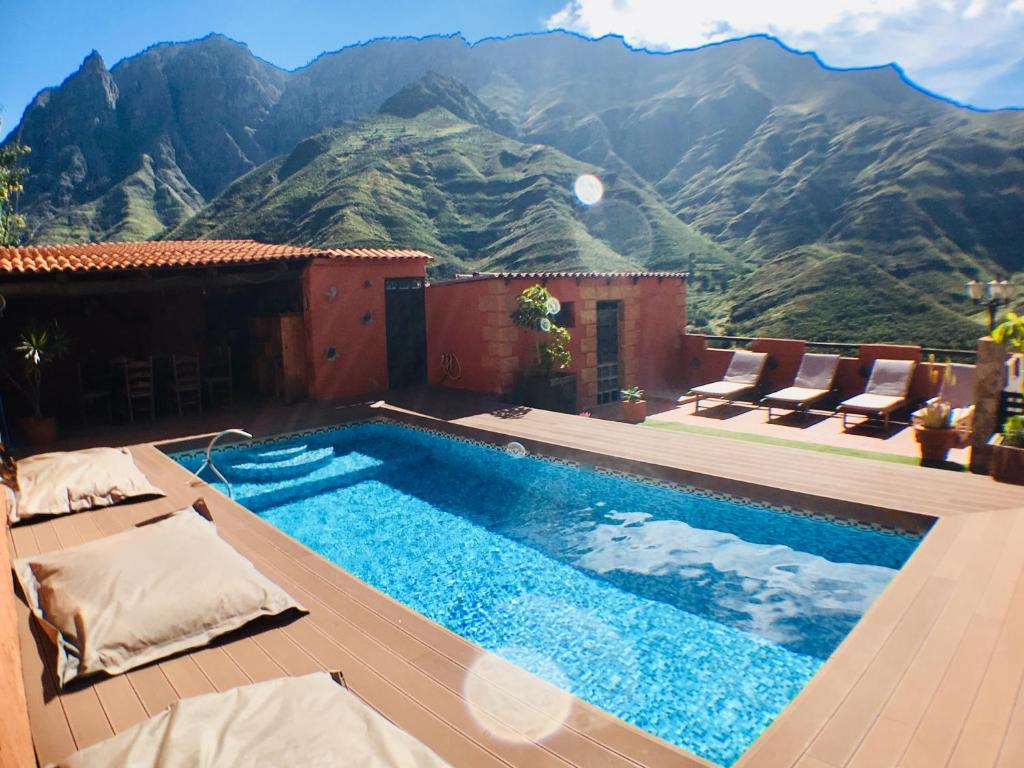 a swimming pool with mountains in the background at La Casa Del Valle in Agaete