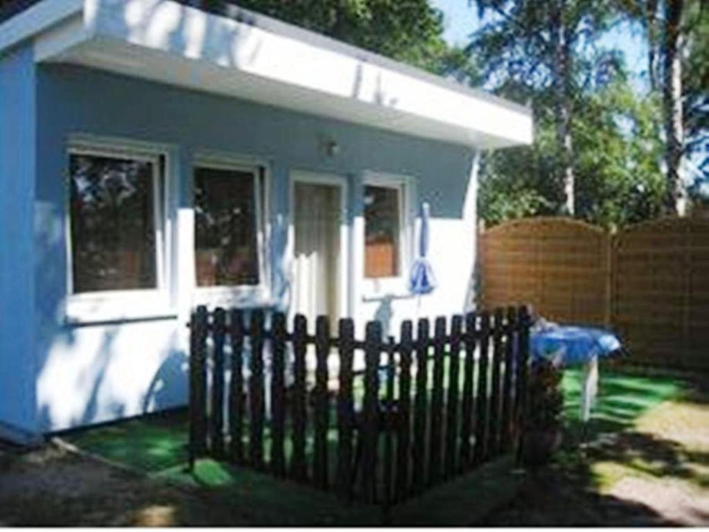 a small house with a fence in front of it at Bungalow Iris in Zinnowitz