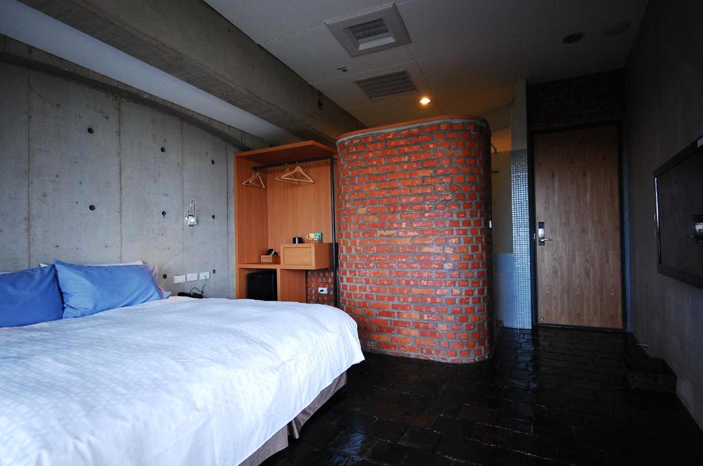 a bedroom with a brick wall next to a bed at The Light in Hengchun South Gate