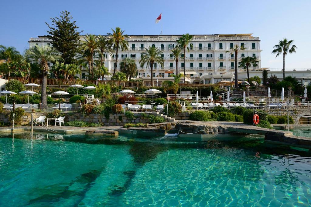 uma piscina em frente a um grande edifício em Royal Hotel Sanremo em Sanremo