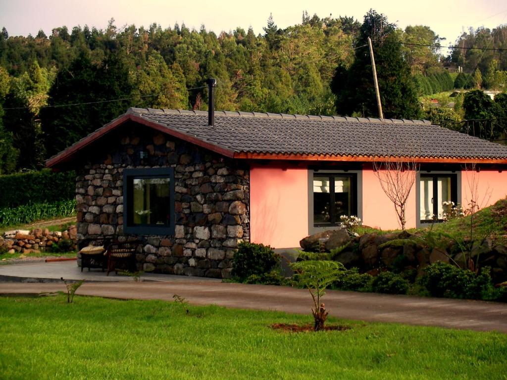 uma pequena casa com uma parede de pedra em Palheiro do Avô em Santa Cruz - Madeira