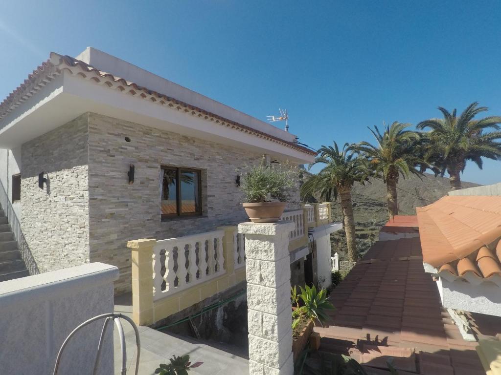 Casa con balcón con palmeras en Casa Rural La Vega en Alojera
