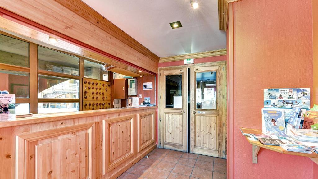 a restaurant with wood paneled walls and a counter at Vacancéole - Résidence Vega in Risoul