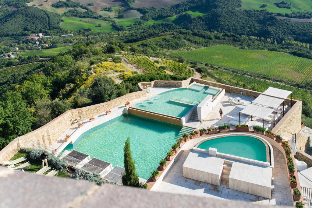 an aerial view of a swimming pool on a house at Castello di Velona Resort, Thermal SPA & Winery in Montalcino