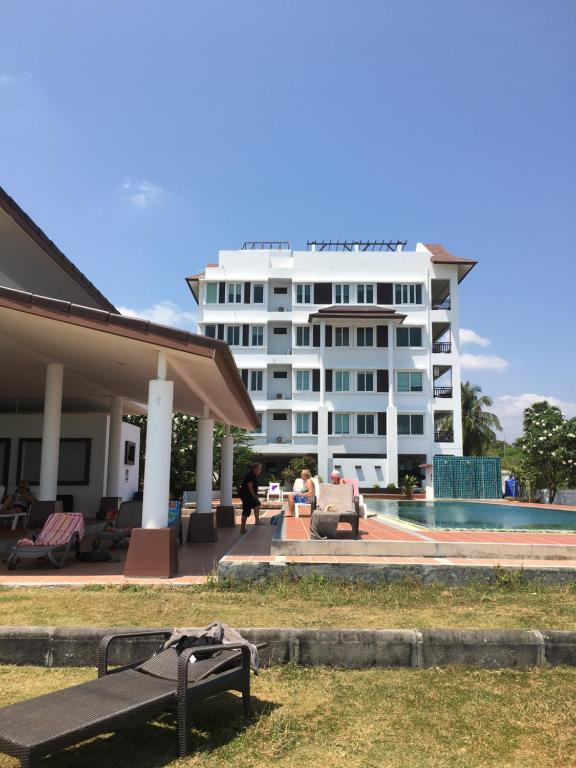 um grande edifício branco com uma piscina em frente em Khanom Beach Residence Rental Condo em Khanom