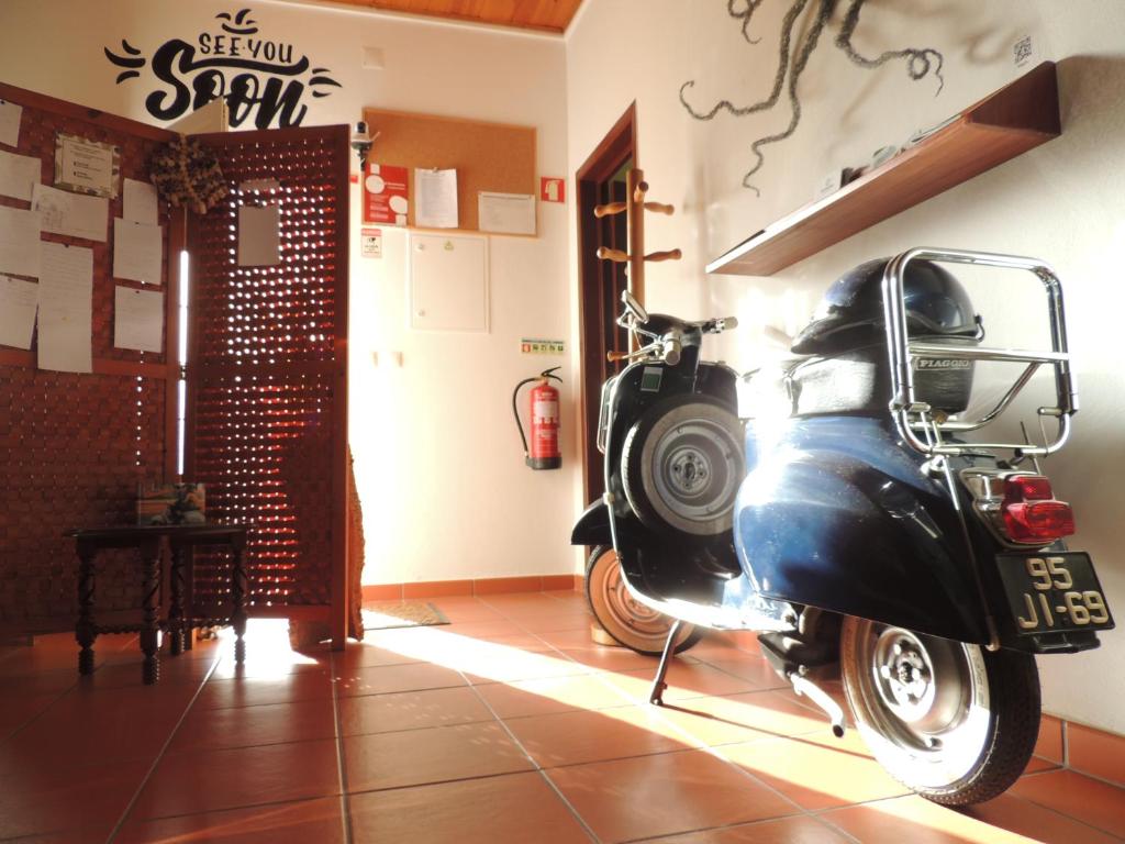 a motor scooter is parked in a room at Hostel Nature in Zambujeira do Mar