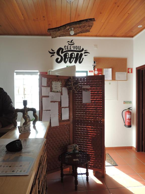 a store with a sign on the wall of a room at Hostel Nature in Zambujeira do Mar