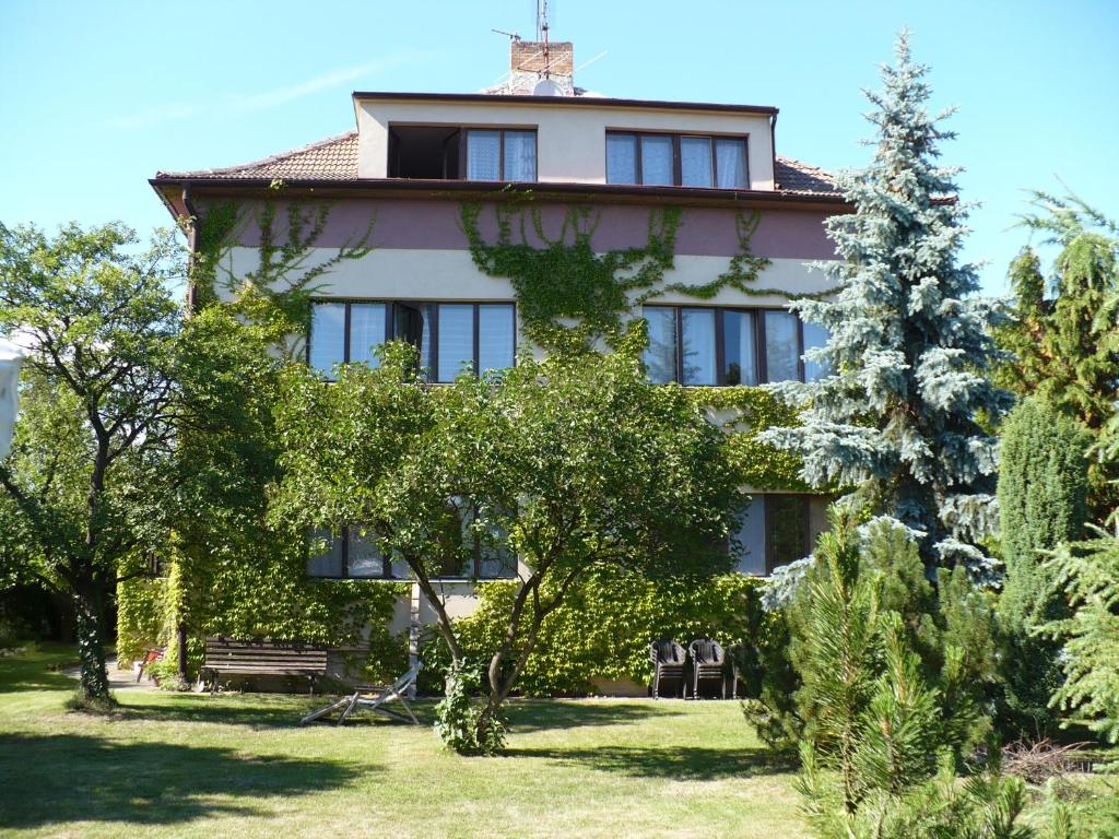 une grande maison avec des arbres devant elle dans l'établissement Penzion Sport, à Třeboň