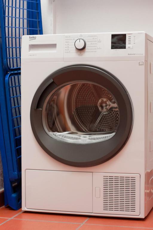 a white washing machine with its door open at Hostel Nature in Zambujeira do Mar