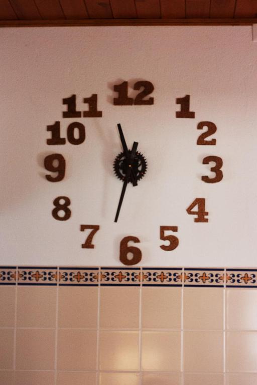 a clock on top of a tiled wall at Hostel Nature in Zambujeira do Mar