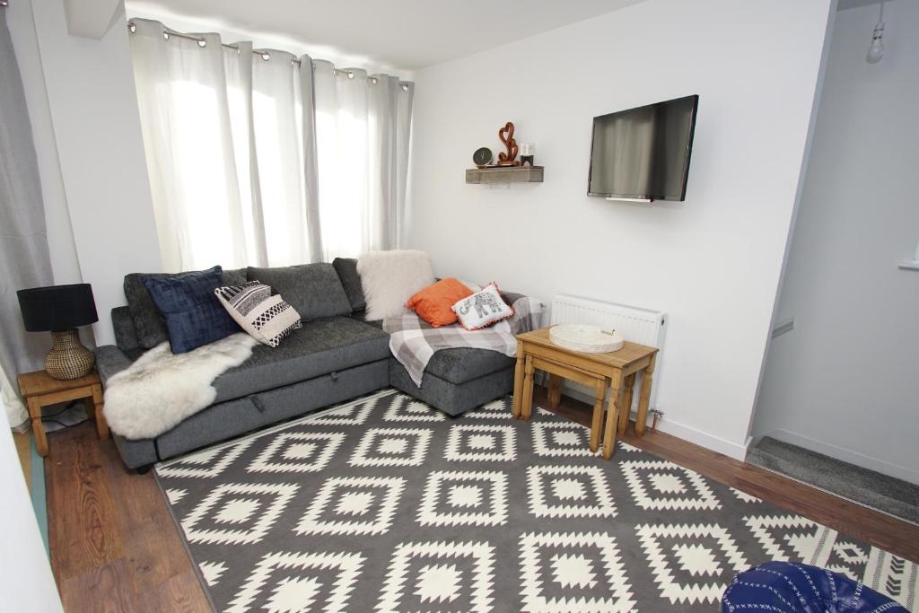 ein Wohnzimmer mit einem Sofa und einem TV in der Unterkunft Apartment 3 Broadhurst Court sleeps 4 minutes from town centre & train in Stockport