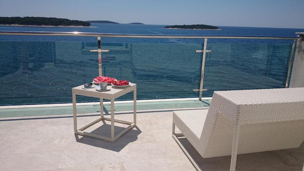 - une table fleurie sur le balcon dans l'établissement Apartments Toni Sea view, à Primošten