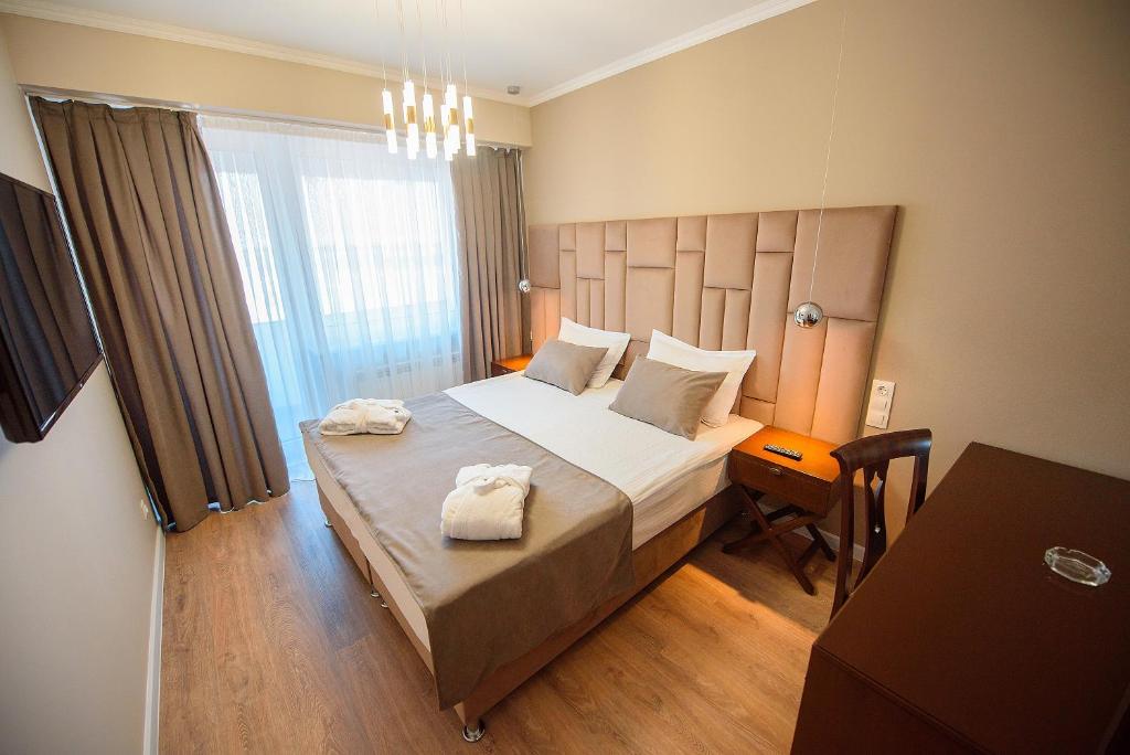ein Schlafzimmer mit einem Bett mit zwei Handtüchern darauf in der Unterkunft Astana International Hotel in Almaty