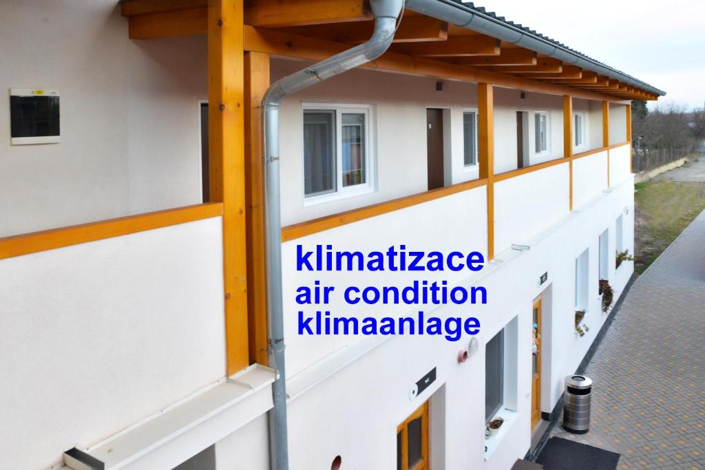 een bord aan de zijkant van een gebouw met airconditioning voor onderhoud bij Penzion Klimeš in Hustopeče