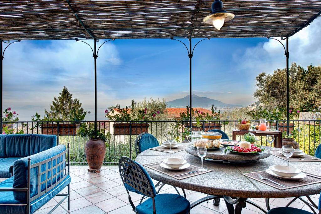 una mesa y sillas en un patio con vistas en Casa Vacanze Villa Antonella by Gocce, en Vico Equense