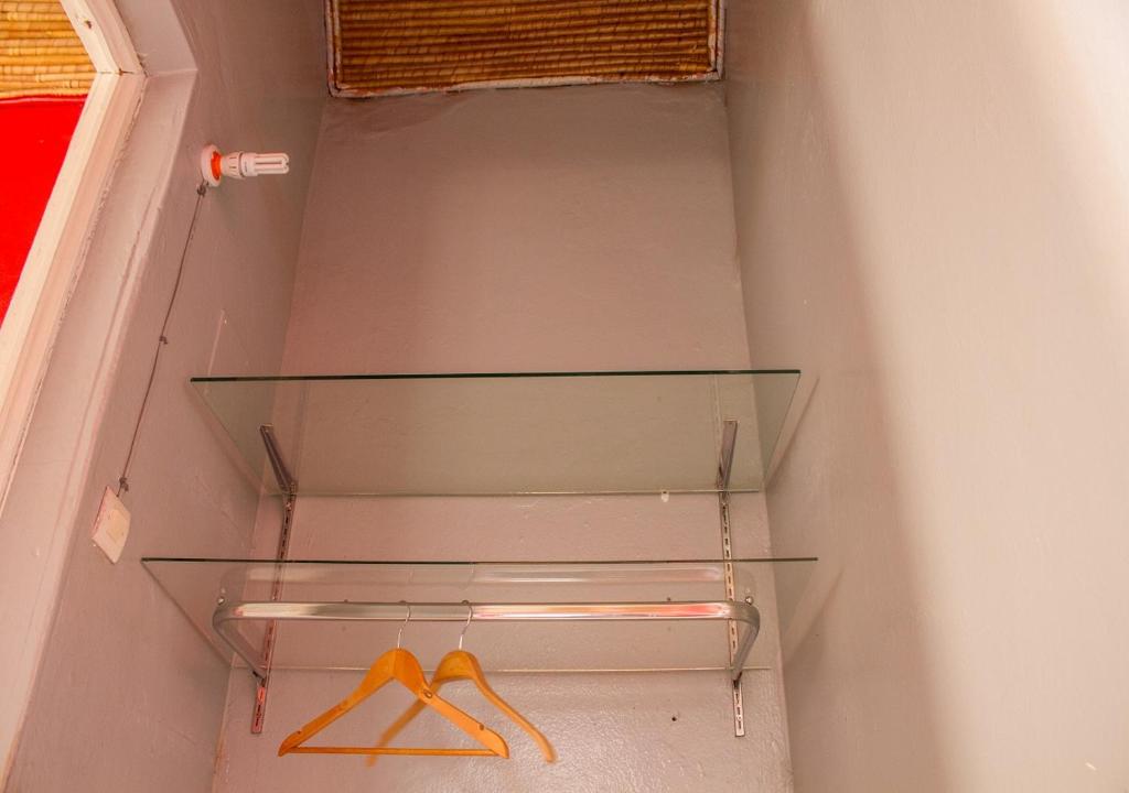 a closet with glass shelves and two hangers at Melia Hotel in Saly Portudal