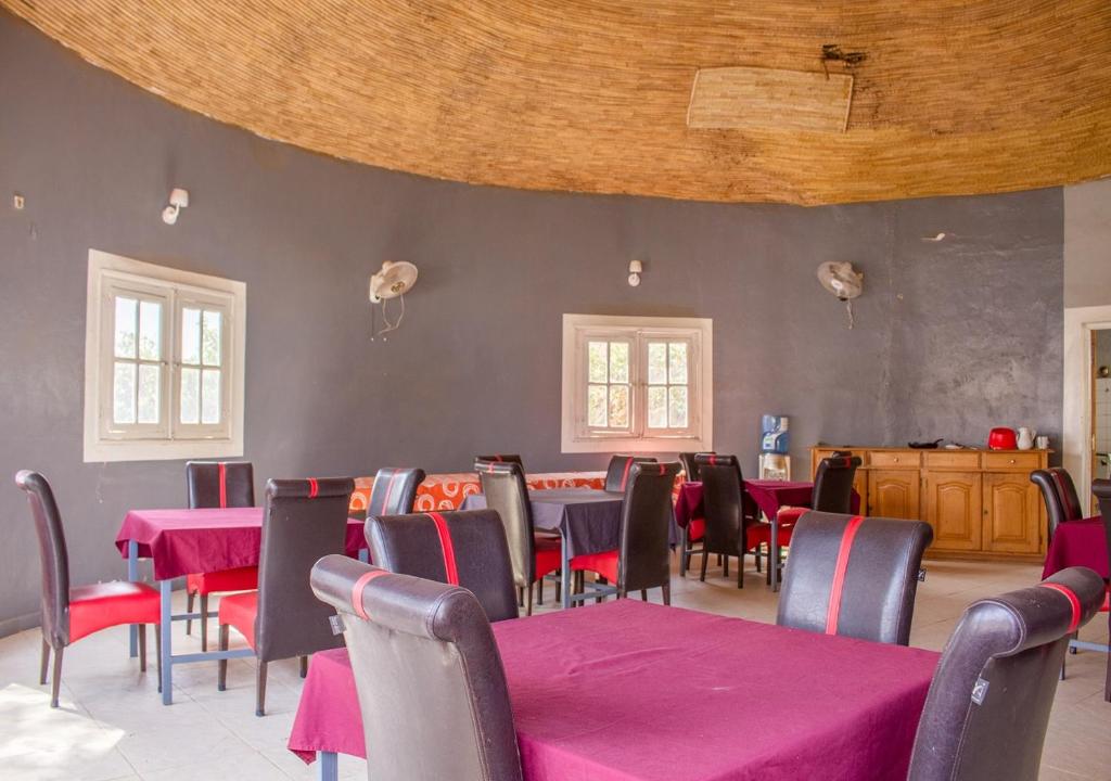 a dining room with tables and chairs with pink table cloth at Melia Hotel in Saly Portudal