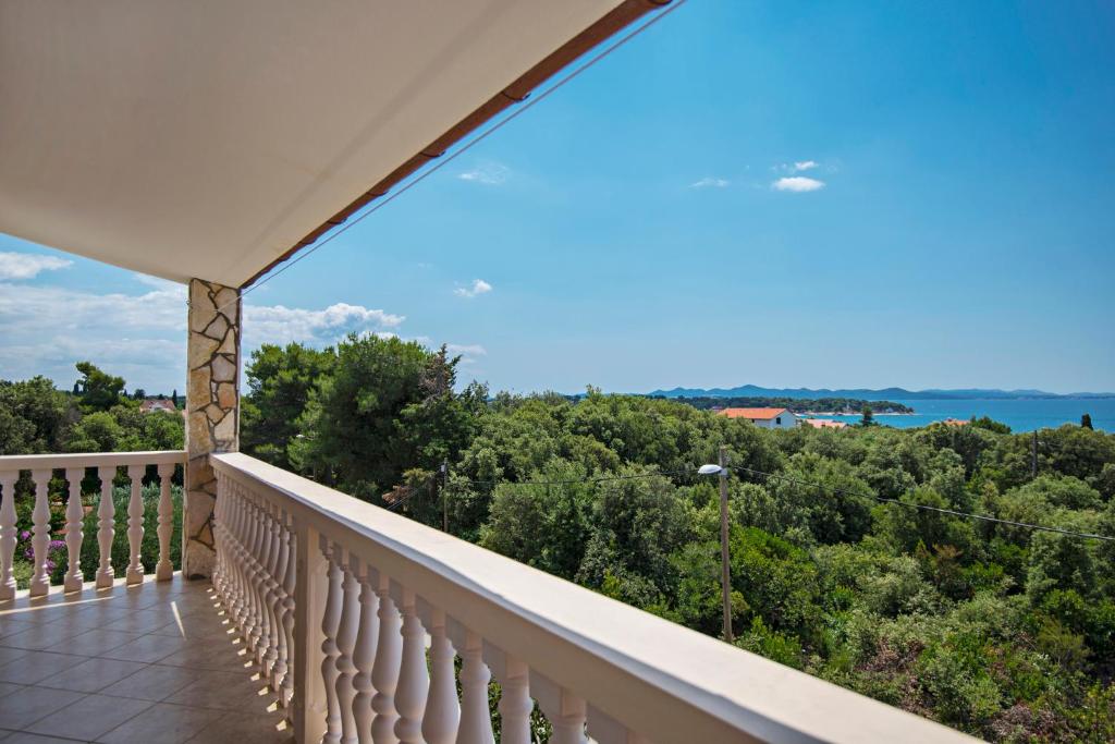 a balcony with a view of the ocean at Apartments Petrčane Welcome in Petrcane