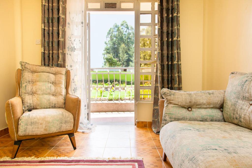 a living room with a couch and a chair at Ashville Homes Meru in Meru