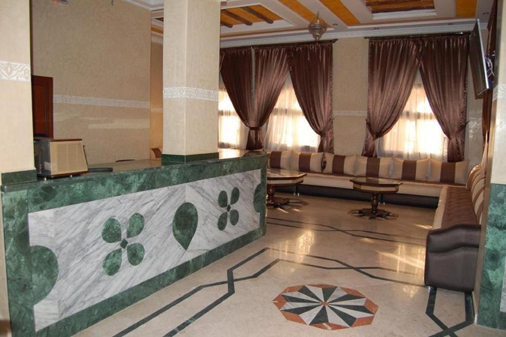 a large living room with a couch and windows at Hotel AMOUDOU فندق أمودو in Tiznit