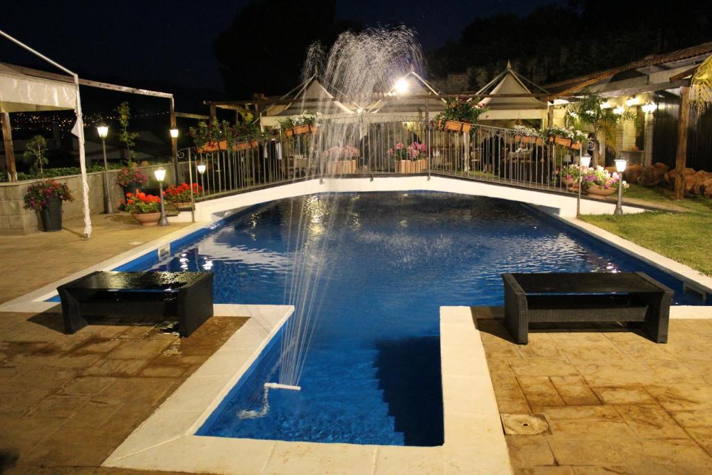 a swimming pool at night with a fountain at B&B Montereale in Monreale