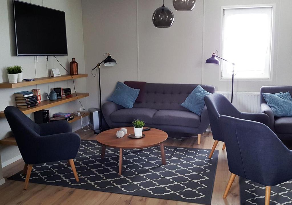sala de estar con sofá, 2 sillas y mesa en Hvammstangi Hostel, en Hvammstangi