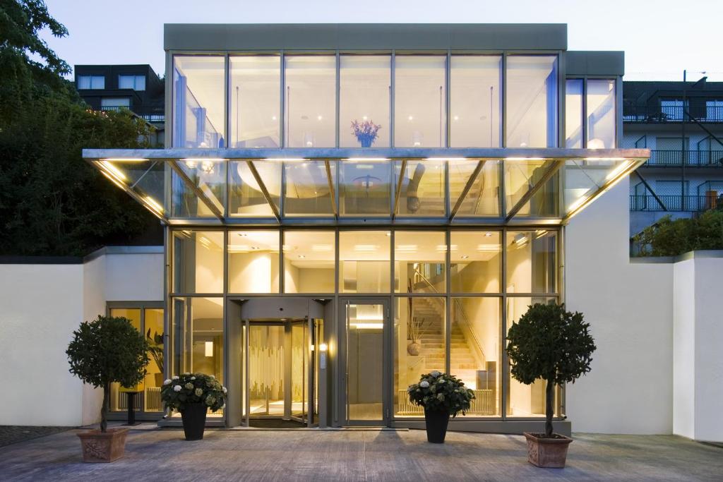 une maison en verre avec deux plantes en pot devant elle dans l'établissement Engimatt City & Garden Hotel, à Zurich