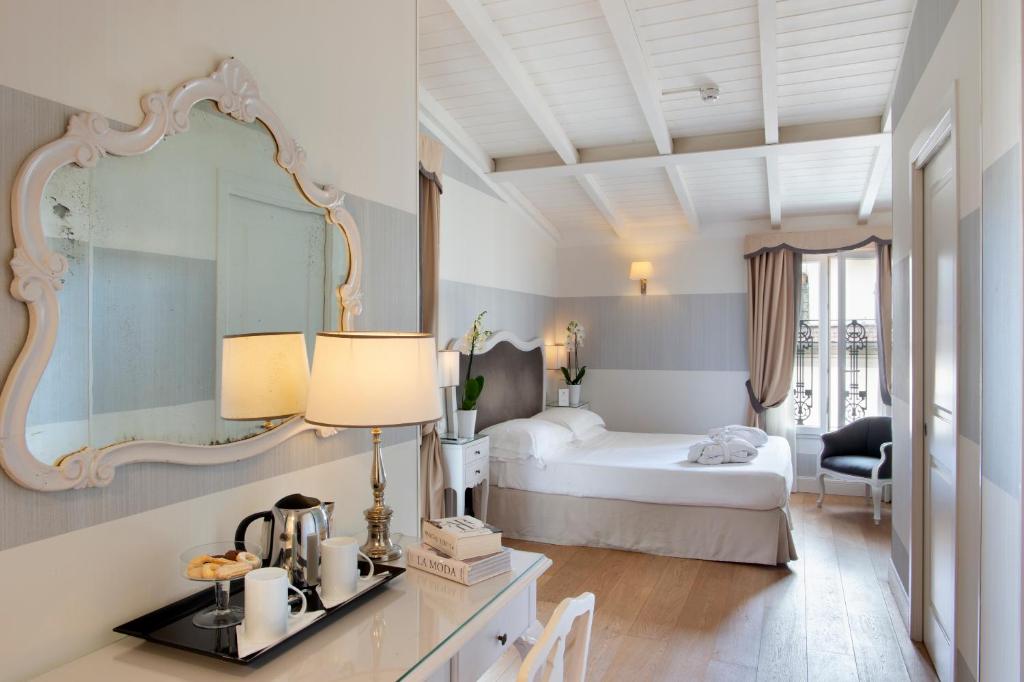 - une chambre d'hôtel avec un lit et un miroir dans l'établissement Hotel Rapallo, à Florence