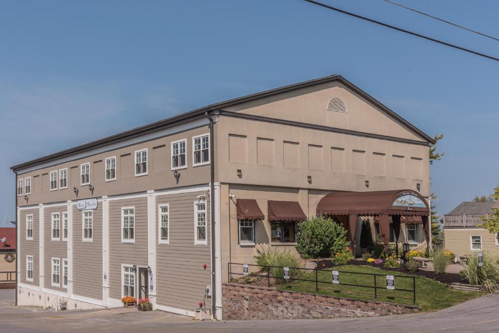 a large gray building with white windows at Harbor House Inn in Sackets Harbor